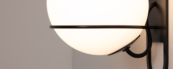 Cradle wall sconce shown in blackened steel finish, zoomed in to detail of wiring and mounting