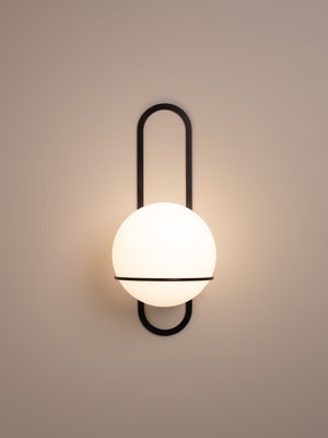 Cradle wall sconce shown in blackened steel finish, front view, illuminated