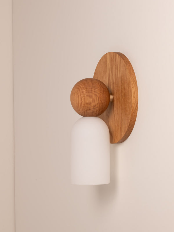 Libby wall sconce shown in warm oak finish, side angle