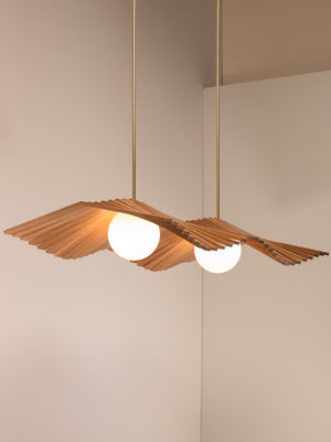 Wave II chandelier shown in natural oak and natural brass finishes, side angle, illuminated