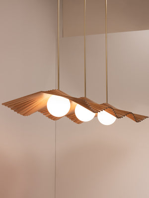 Wave III chandelier shown in natural oak and natural brass finishes, side angle, illuminated