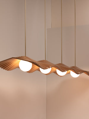 Wave IV chandelier shown in natural oak and natural brass finishes, side angle, illuminated